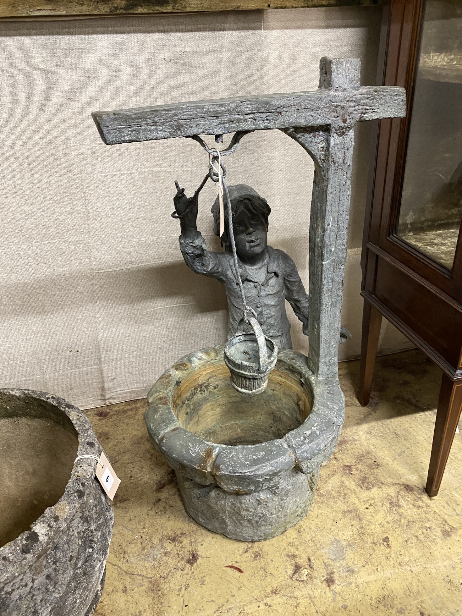 A cast metal garden bird bath modelled as a boy at a well, height 79cm